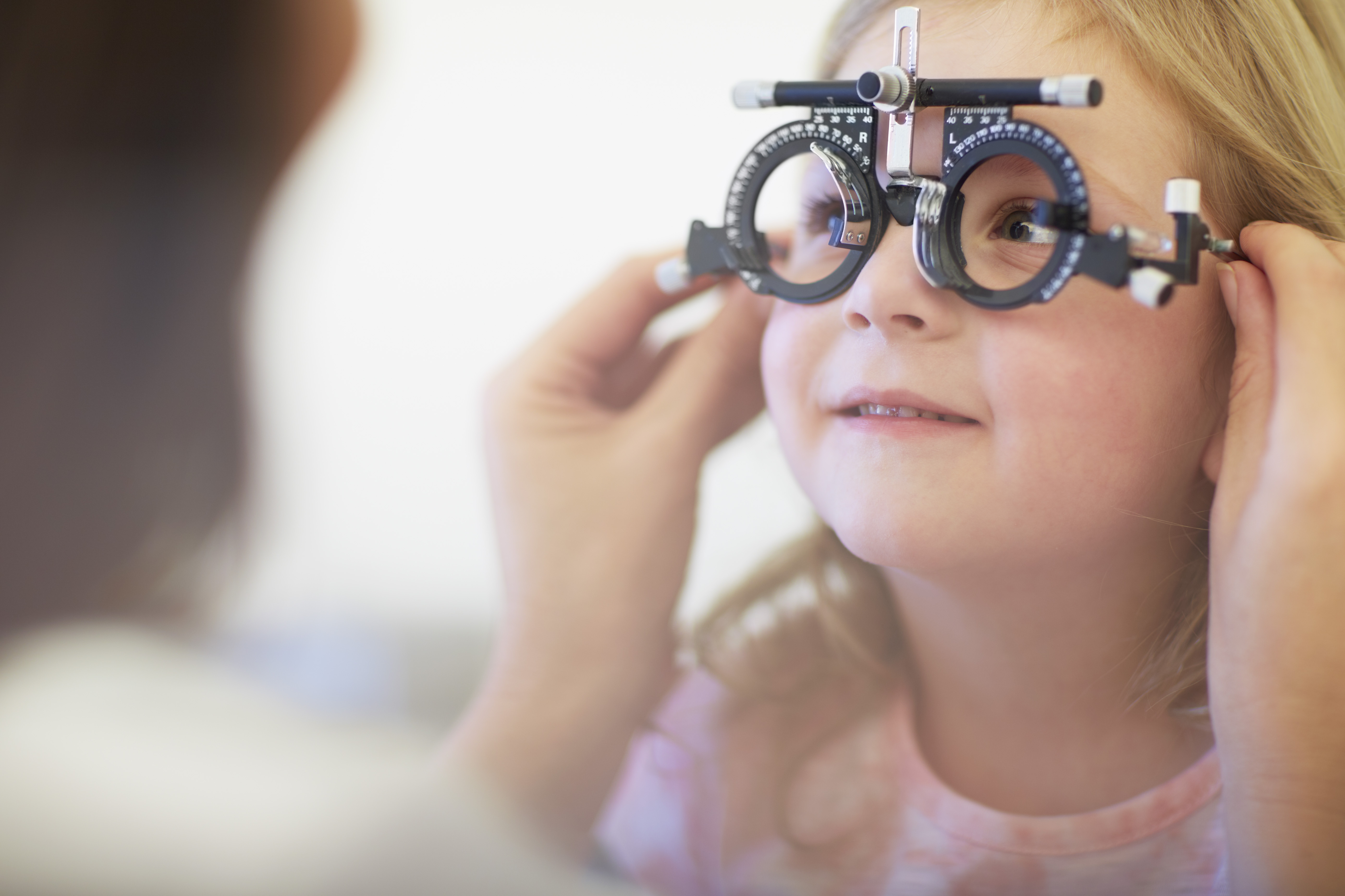 Eye doctor examining girl's vision